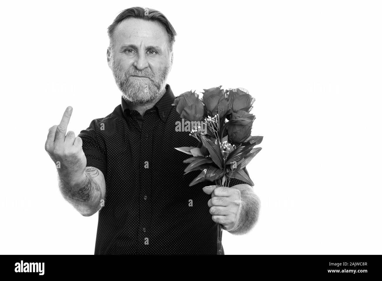 Studio shot of mature man holding barbus roses, tout en montrant son majeur Banque D'Images
