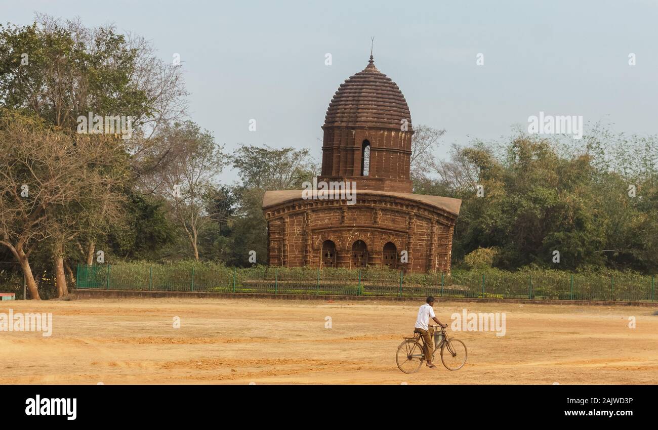 Bishnupur, Bengale de l'Ouest/Inde - 7 février 2018: Un homme sur un vélo passe devant l'ancien temple hindou de Nandalal. Banque D'Images