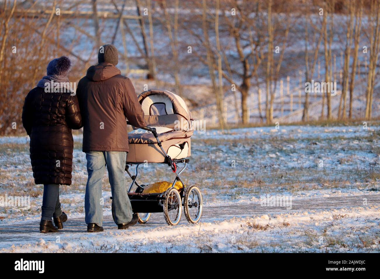 Couple avec une poussette de bébé balade dans Winter Park au cours. Temps de neige, notion de maternité, les parents avec poussette Banque D'Images