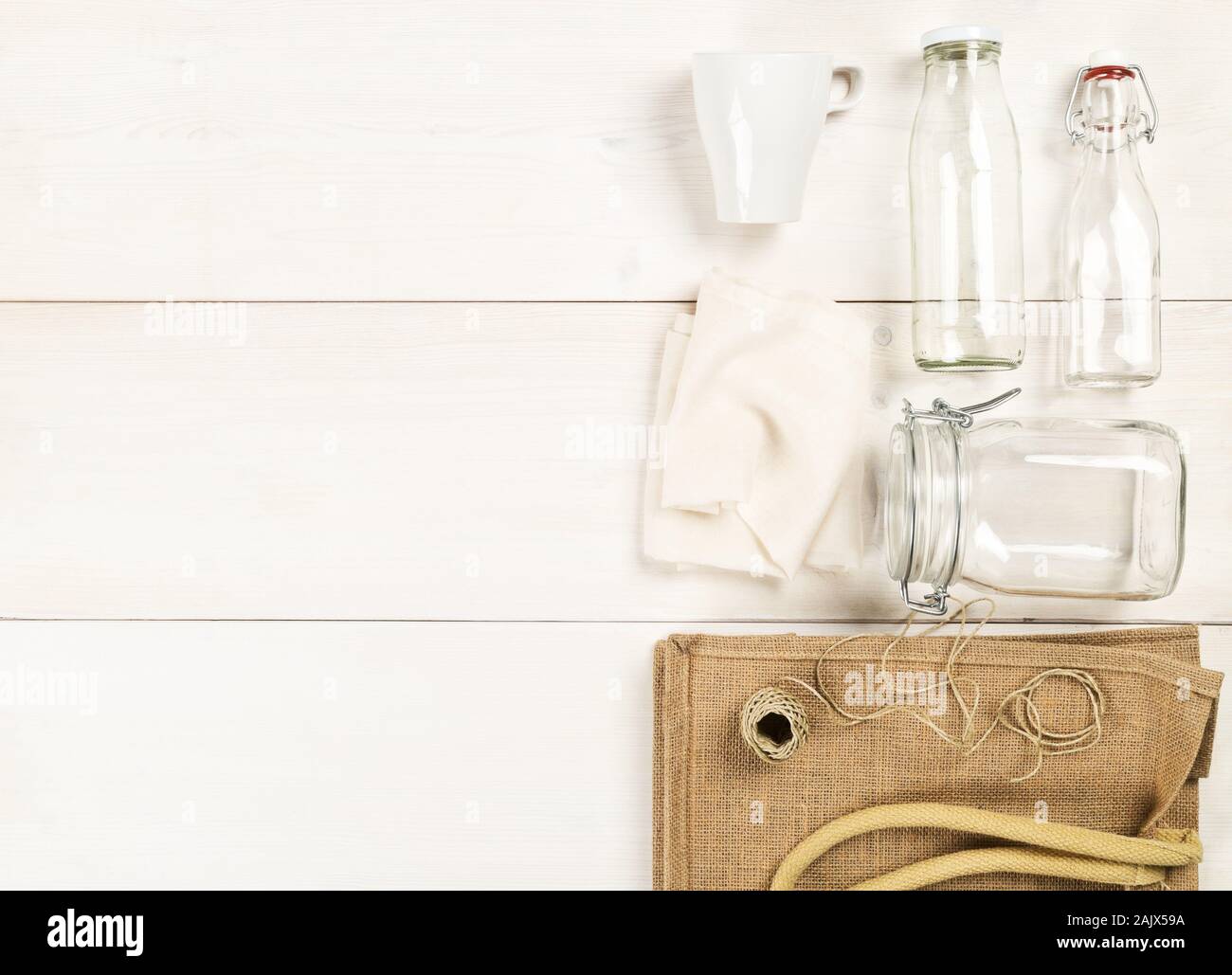 Zéro Déchets déchets ou free shopping ustensiles avec sac de toile, des bouteilles en verre et sac de coton blanc sur fond de table en bois de mise à plat au-dessus - Déchets Banque D'Images