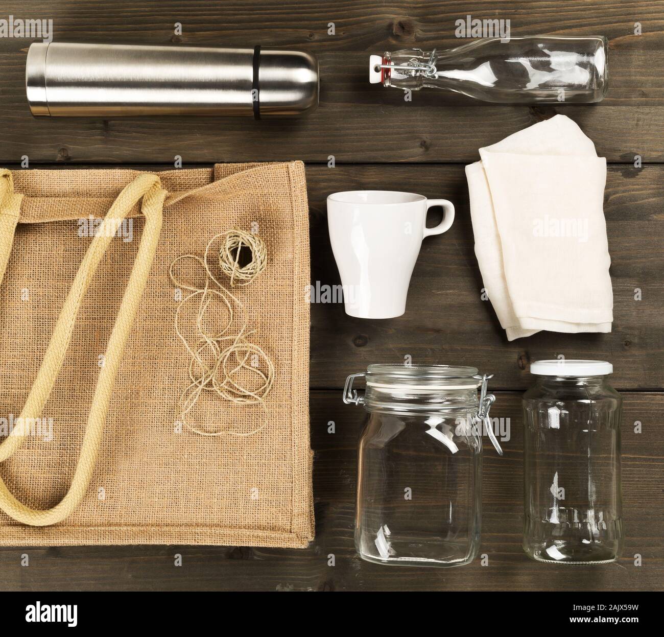 Zéro Déchets déchets ou free shopping ustensiles avec sac de toile, des bouteilles en verre et sac de coton sur fond de table en bois brun de poser à plat au-dessus - Déchets Banque D'Images