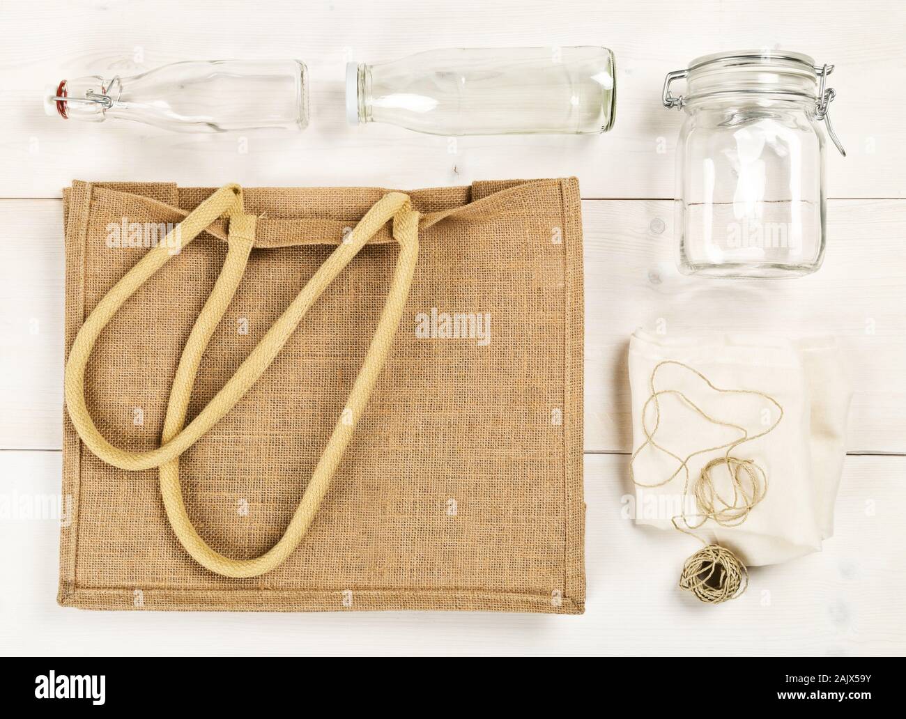 Zéro Déchets déchets ou free shopping ustensiles avec sac de toile, des bouteilles en verre et sac de coton blanc sur fond de table en bois de mise à plat au-dessus - Déchets Banque D'Images