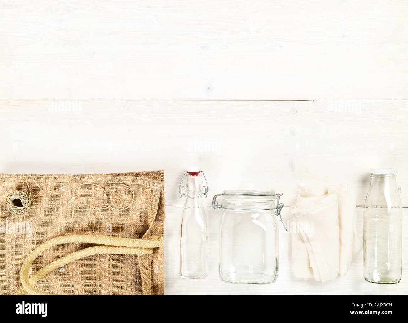 Zéro Déchets déchets ou free shopping ustensiles avec sac de toile, des bouteilles en verre et sac de coton blanc sur fond de table en bois de mise à plat au-dessus - Déchets Banque D'Images
