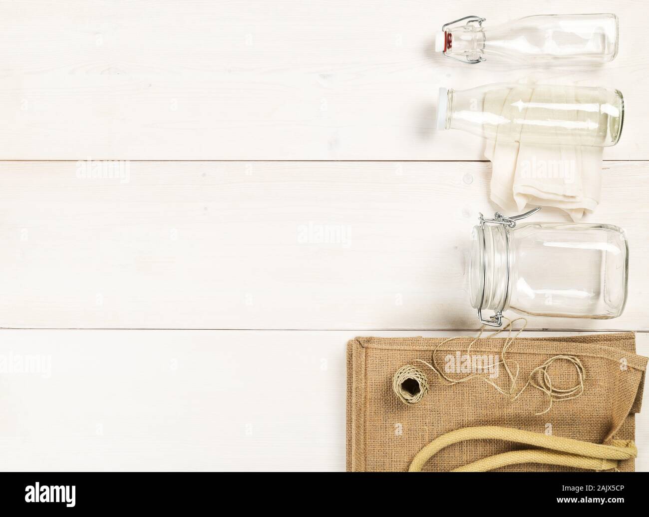 Zéro Déchets déchets ou free shopping ustensiles avec sac de toile, des bouteilles en verre et sac de coton blanc sur fond de table en bois de mise à plat au-dessus - Déchets Banque D'Images
