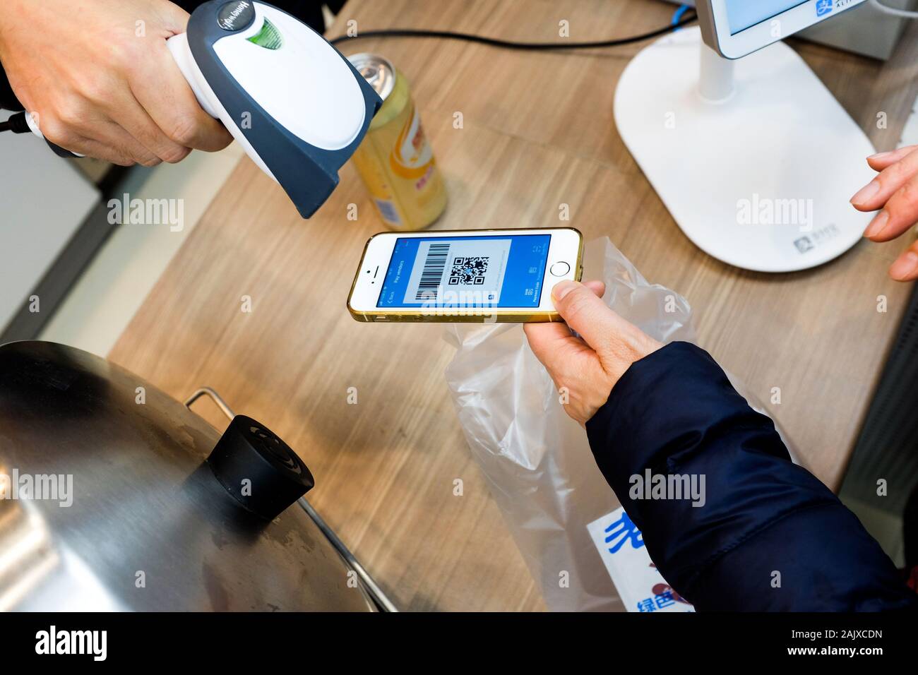 Un client à Xiamen, en Chine, à l'aide de leur smartphone pour payer des marchandises via Alipay. Banque D'Images