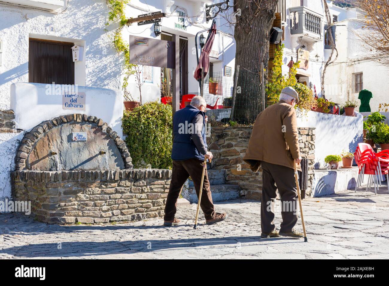 Capileira, La Alpujarra, Alpujarras, région de Grenade, Andalousie, espagne. Les hommes à pied dans le village en passant un printemps frais de montagne fontaine à eau Banque D'Images