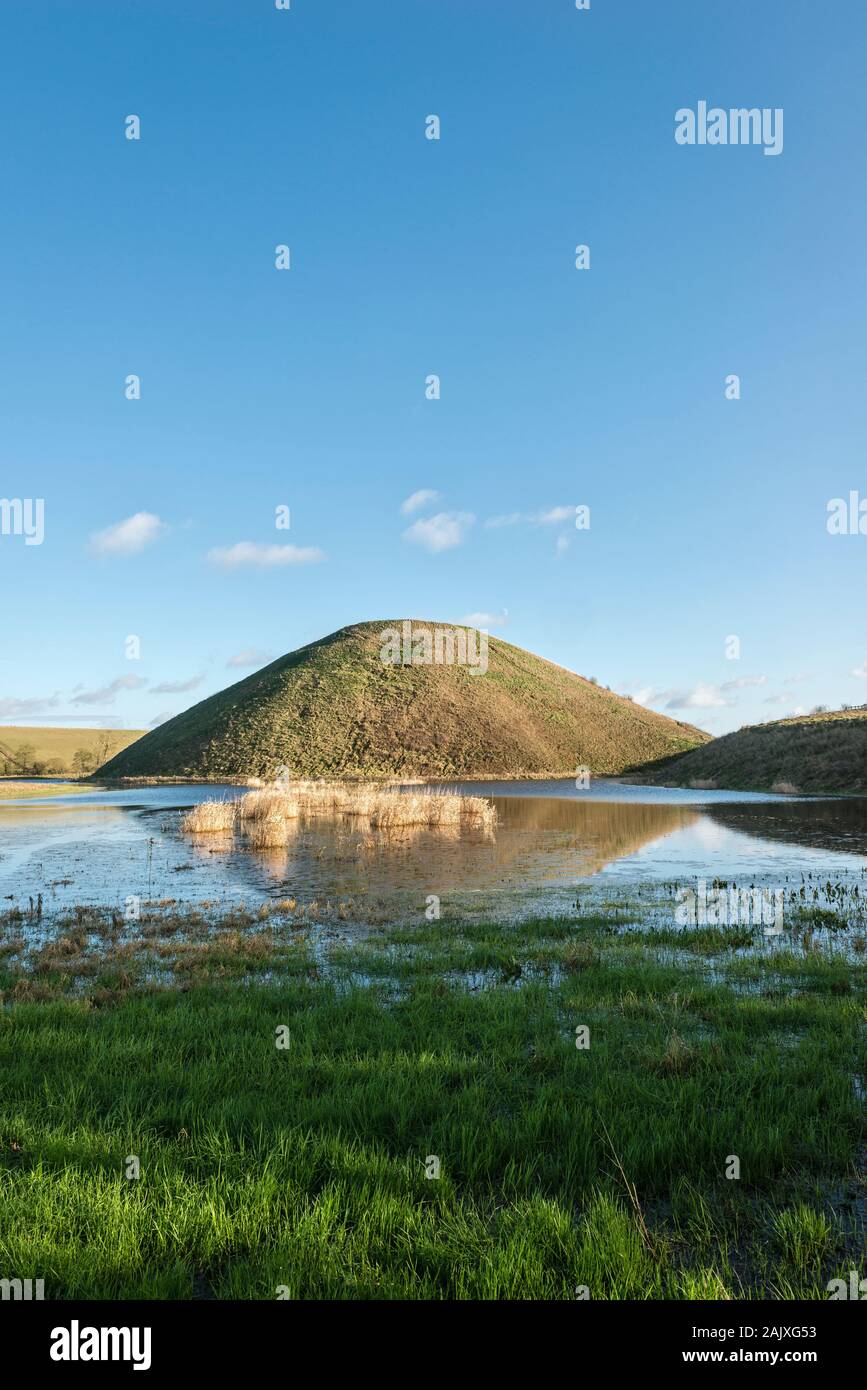 L'énorme craie néolithique de Silbury Hill, Avebury, Wiltshire, Royaume-Uni, se reflète dans un pré inondé. Il fait 40 m de haut et a été construit autour de 2300 BC Banque D'Images