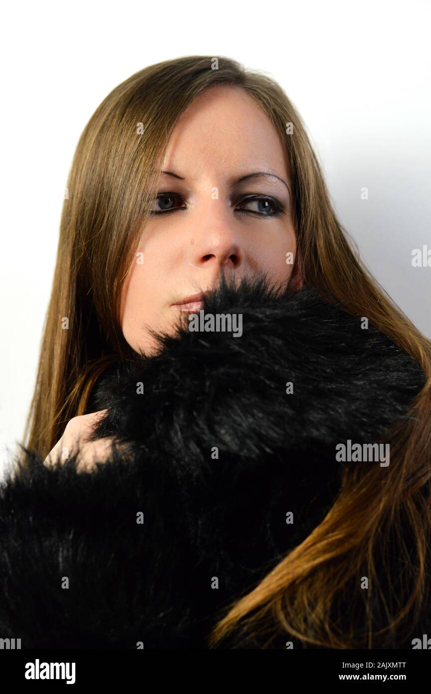 Portrait de belle jeune femme avec les cheveux bruns en manteau de fourrure de faux Banque D'Images