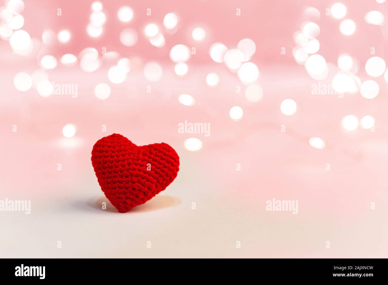 Beau coeur rouge sur fond rose avec des lumières. Valentines Day, symbole de l'amour, roman, datant concept avec copie espace. Stock photo Saint-Valentin Banque D'Images