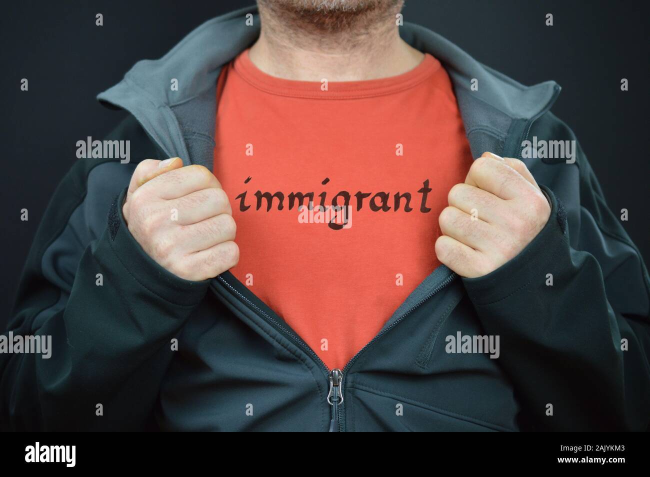 Un homme montrant son t-shirt avec le mot immigrant sur elle Banque D'Images