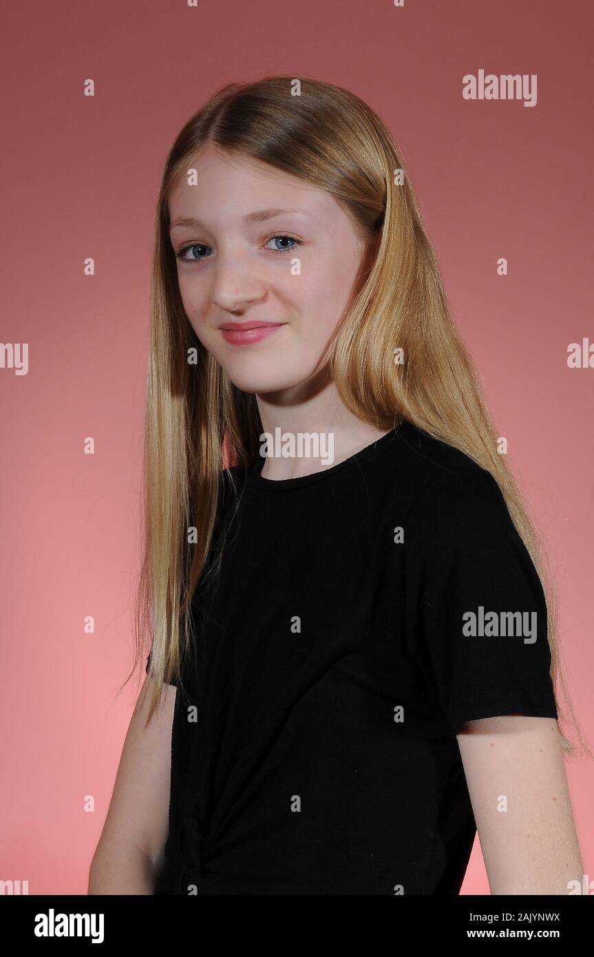 Jolie blonde haired Student graduation dans un t-shirt noir isolé sur un fond lumineux est diplômé Banque D'Images