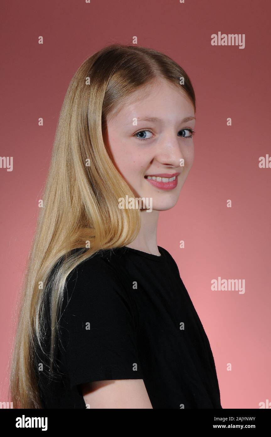 Jolie blonde haired Student graduation dans un t-shirt noir isolé sur un fond lumineux est diplômé Banque D'Images