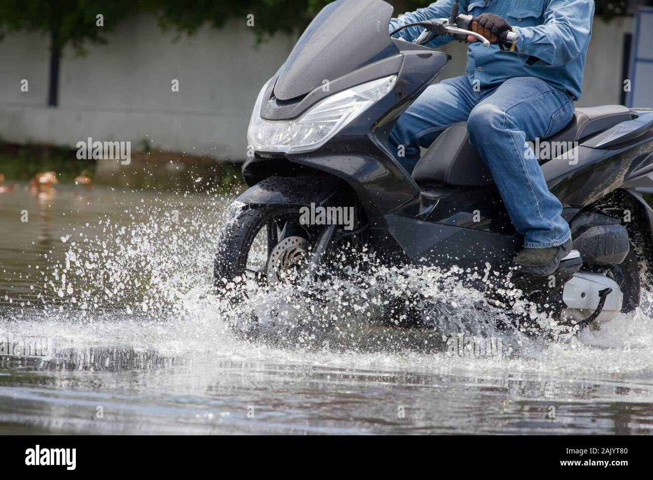 Splash par une moto en passant à travers l'eau d'inondation Banque D'Images