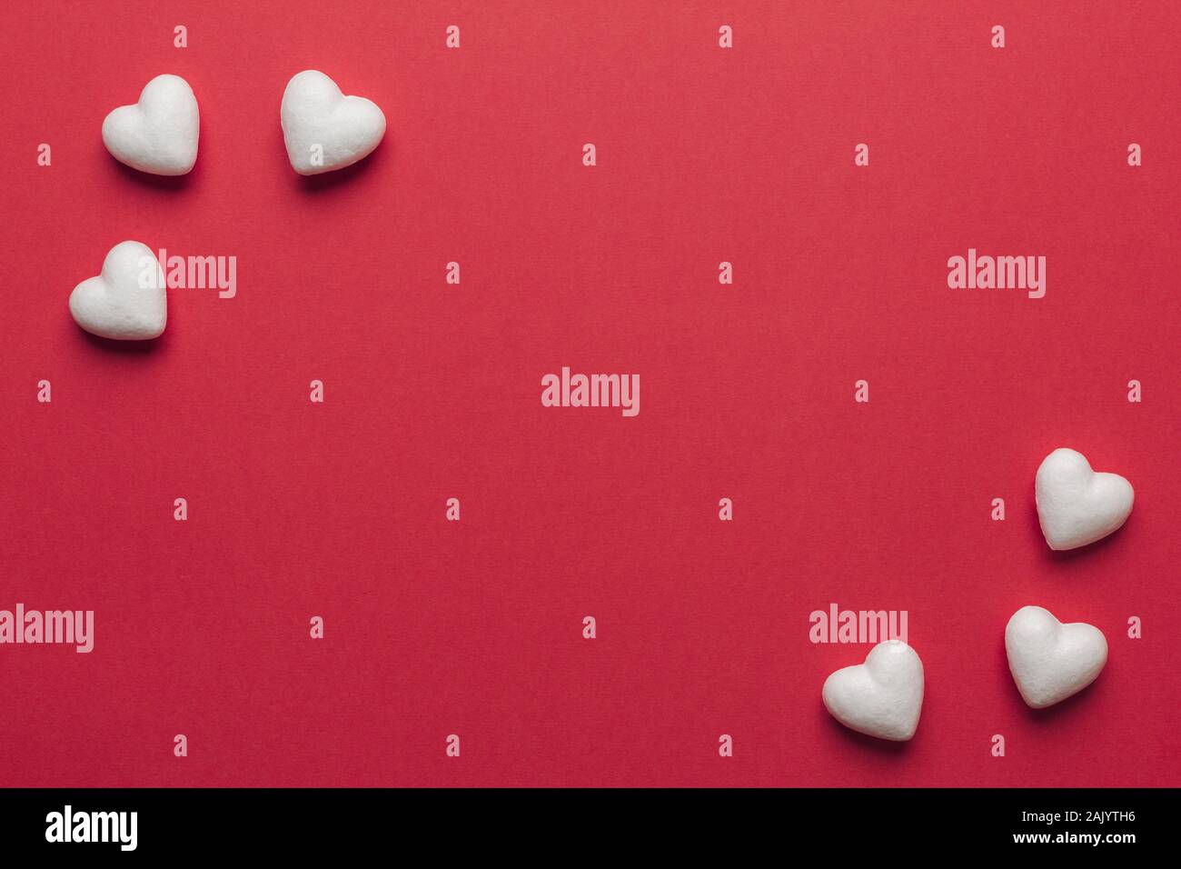 Stock photo de petits coeurs blancs sur fond rouge. Coeurs dans les coins avec un espace pour le texte Banque D'Images