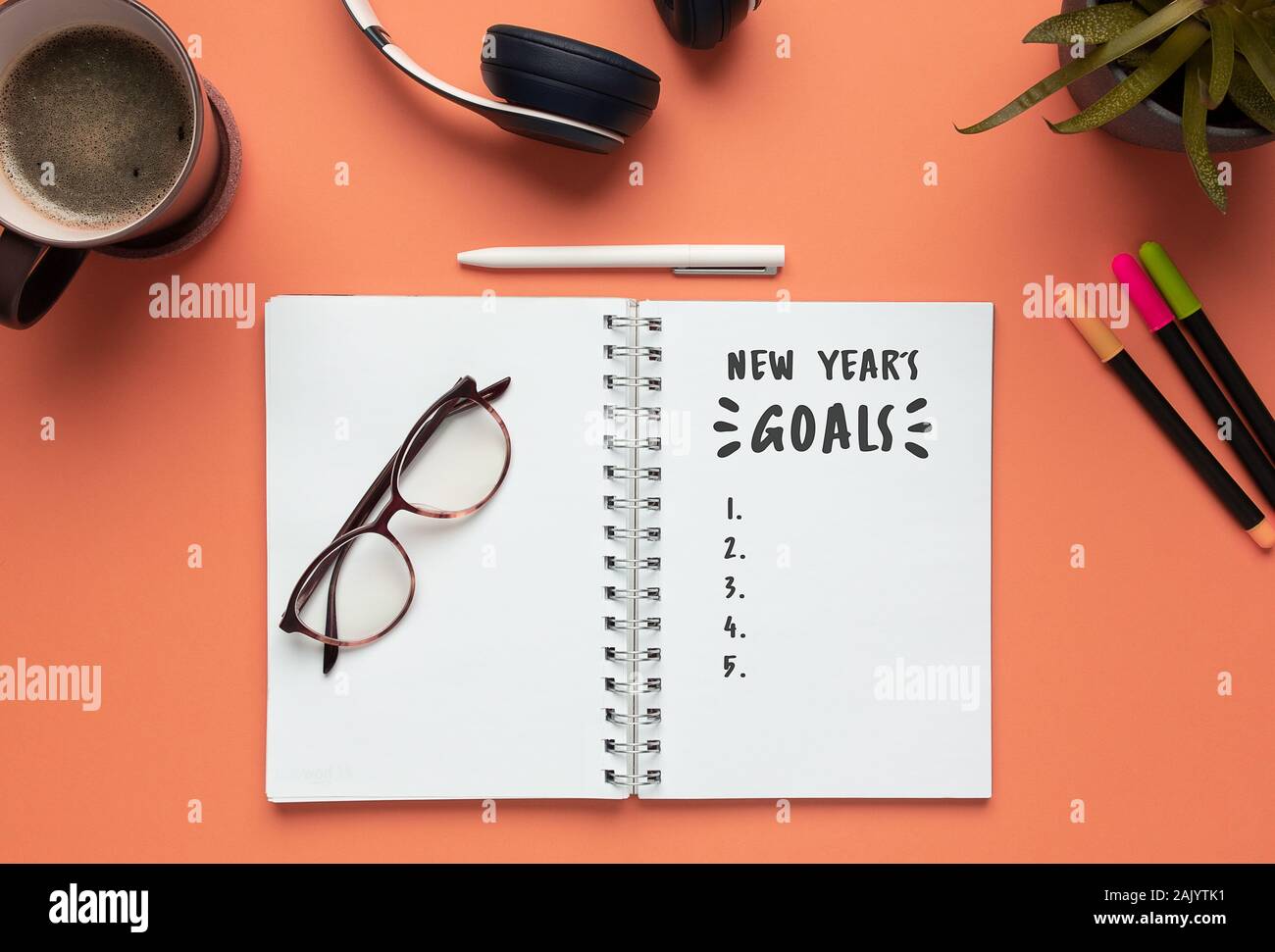 Stock photo de nouvel an 2020 portable avec liste d'objectifs et d'objets sur fond de corail Banque D'Images