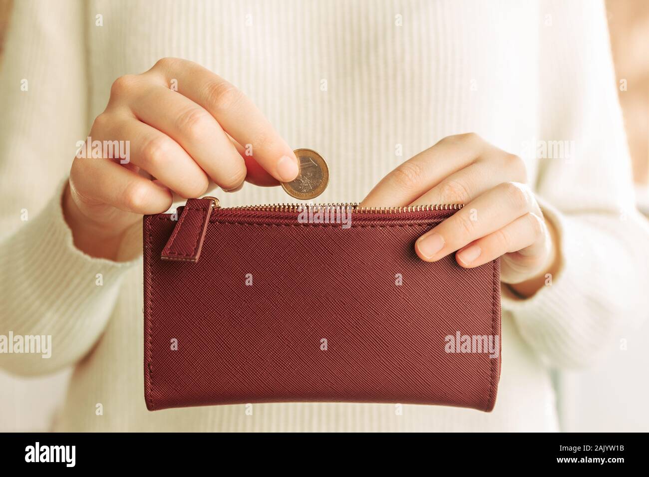 Stock photo d'une femme de mains l'introduction d'une pièce de 1 euro dans un portefeuille Banque D'Images