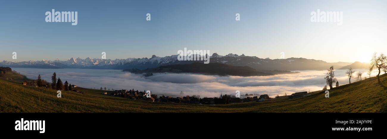 Gamme de montagne suisses en Suisse, alors que la vallée est couverte dans le brouillard pendant le coucher du soleil, super chaude lumière et Ciel clair Banque D'Images