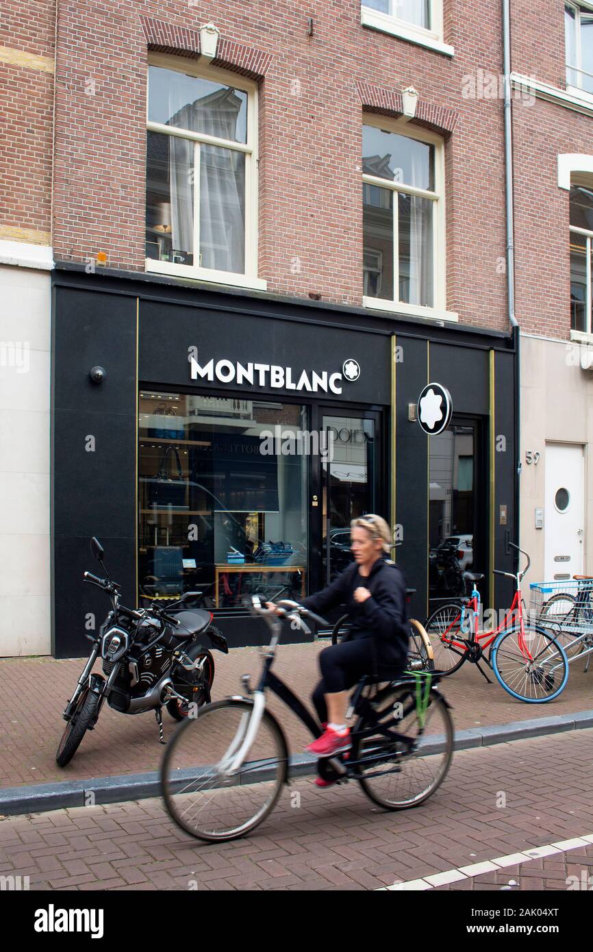 View of woman riding bicycle in blurry motion par écrit du fabricant allemand d'instruments du magasin sur la rue commerçante de luxe nommé 'Pieter Corne Banque D'Images