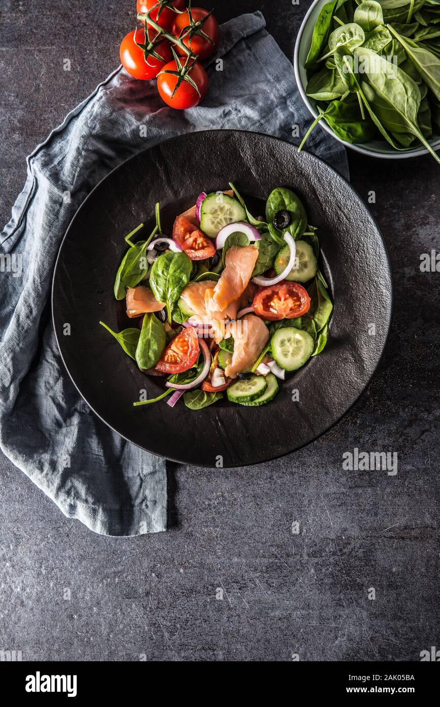 Salade de saumon avec des légumes dans la plaque sur une table de cuisine noir - Haut de la Banque D'Images