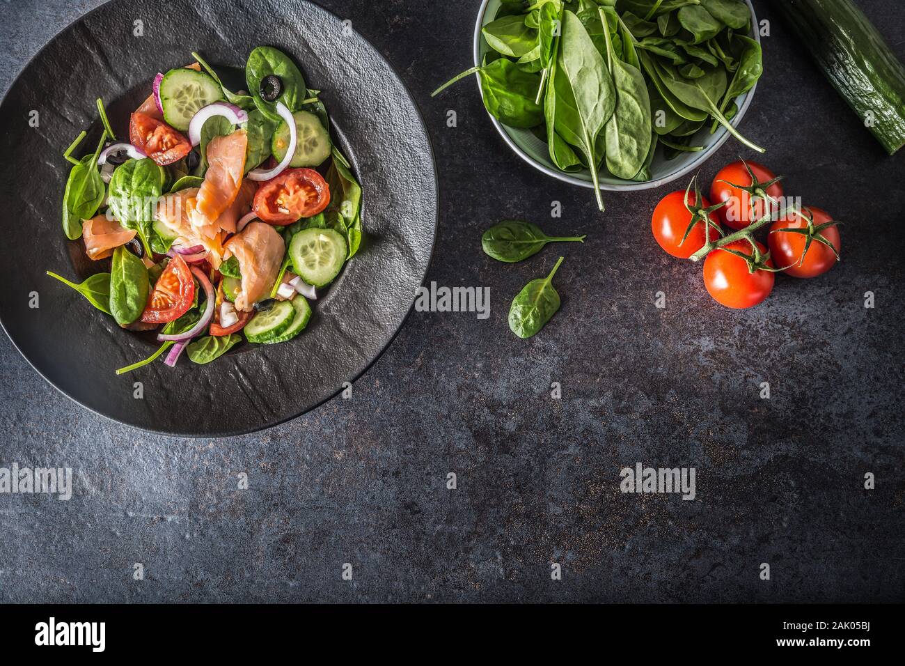 Salade de saumon avec des légumes dans la plaque sur une table de cuisine noir - Haut de la Banque D'Images