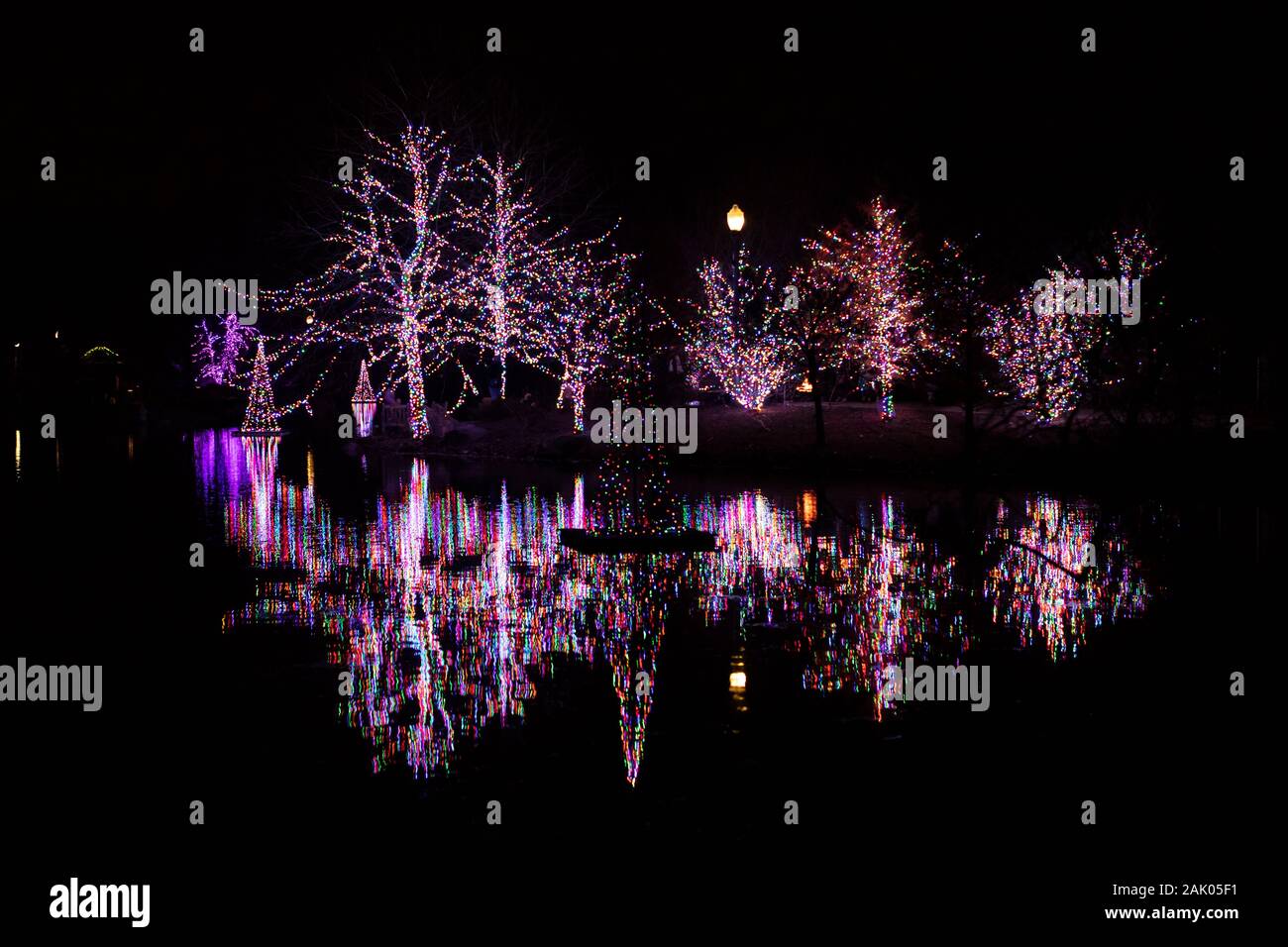 Lumières de Noël reflétant dans le lac à Winter Wonderland Holiday Lights au Wellfield Botanic Gardens à Elkhart, Indiana, États-Unis. Banque D'Images