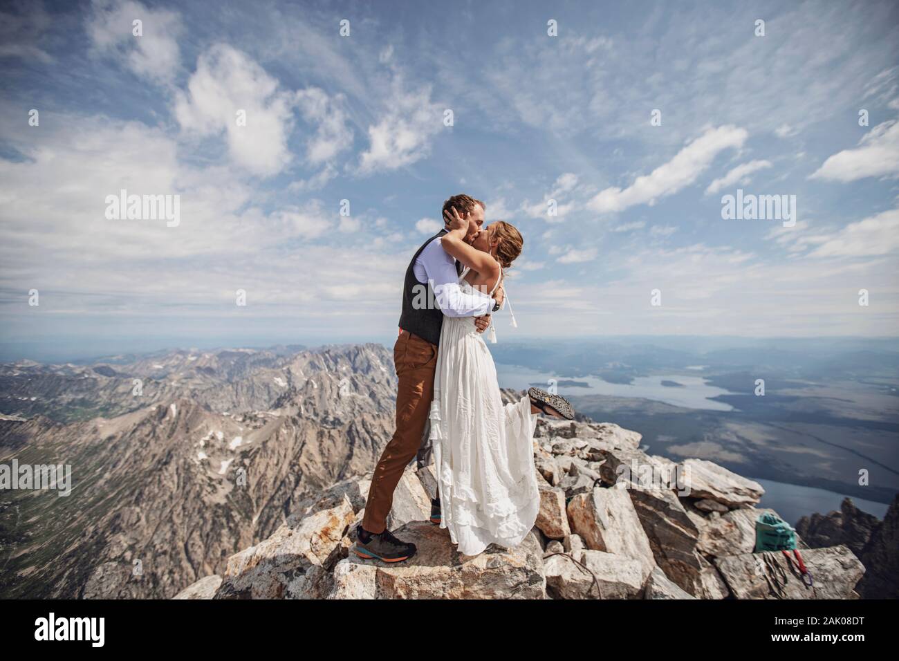Le couple de jeunes mariés a un premier baiser lors du mariage sur le sommet de la montagne, Wyoming. Banque D'Images