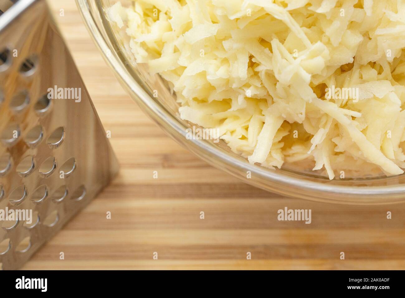 Vue en grand angle des pommes de terre râpées dans un bol sur le comptoir pendant la préparation des aliments Banque D'Images