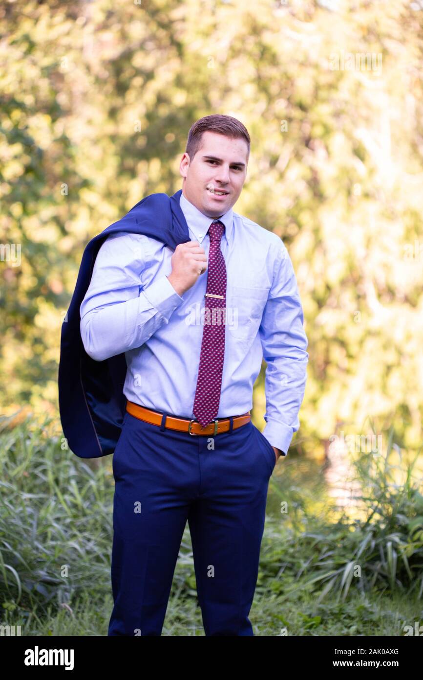 Jeune homme en costume se tient à l'extérieur avec une veste sur l'épaule  Photo Stock - Alamy