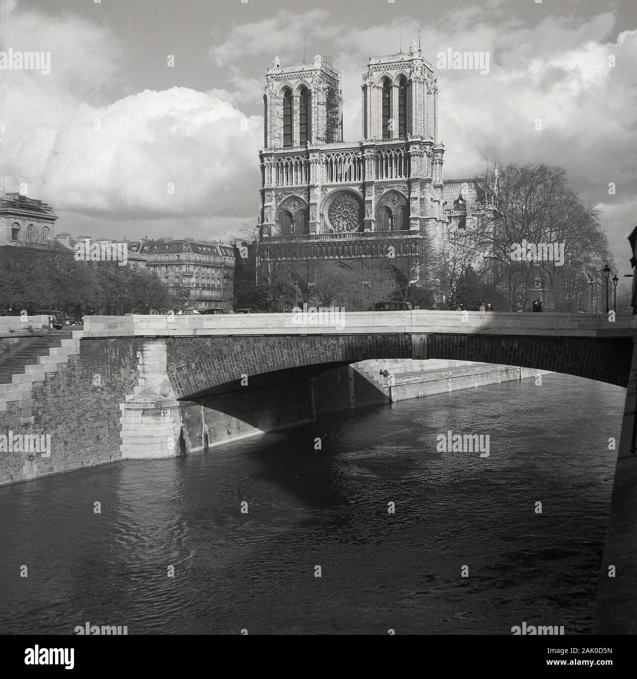 Années 1950, historique, une vue de l'ère de l'autre côté de la rivière Seine du célèbre monument, la cité médiévale de la Cathédrale Notre-Dame, Paris, France, considéré comme l'un des plus beaux exemples de l'architecture gothique française. Banque D'Images