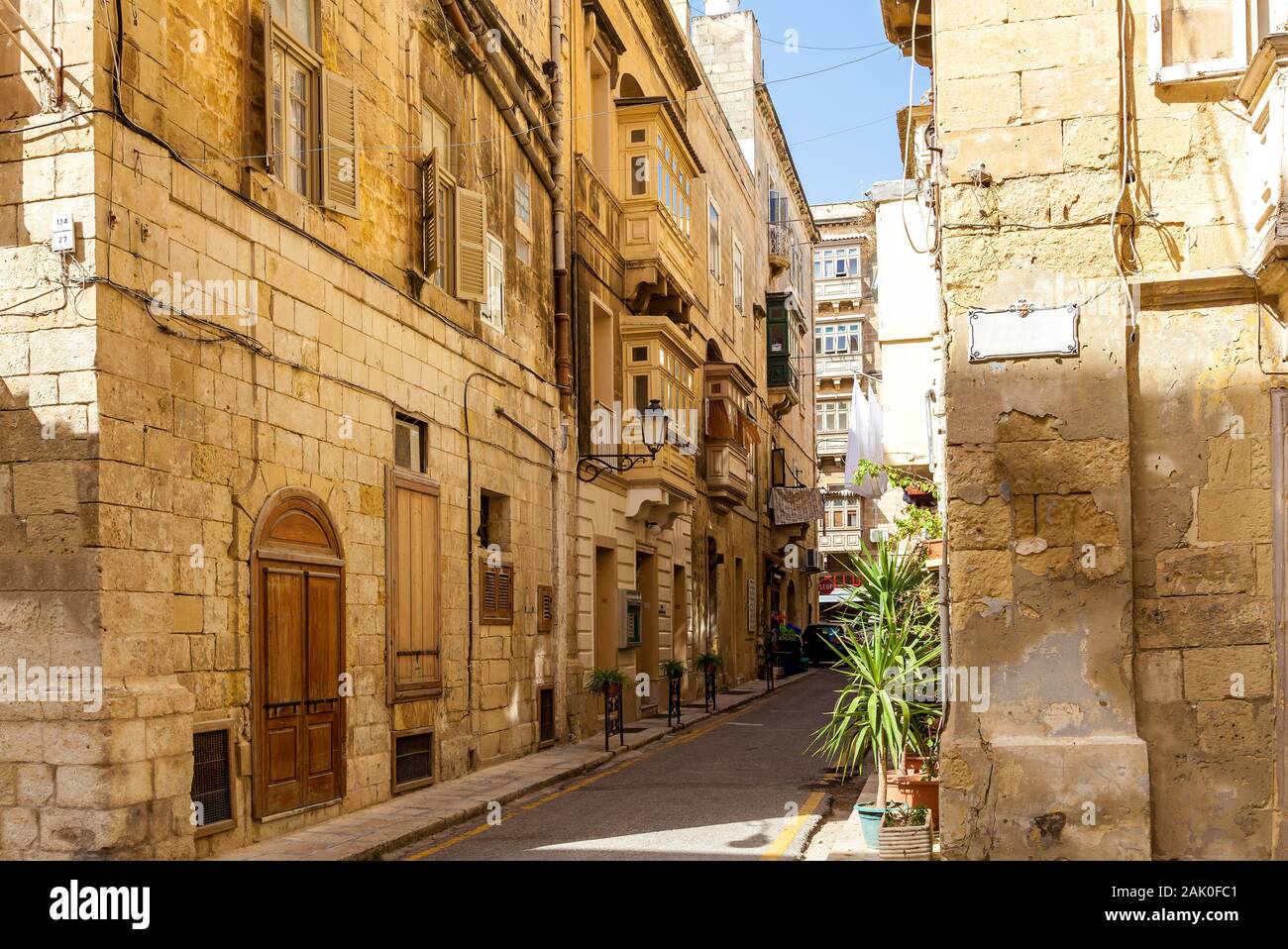 Une belle ruelle à l'architecture typiquement maltais. Le mur de l'édifice décoré d'une sculpture en pierre de saint. Banque D'Images