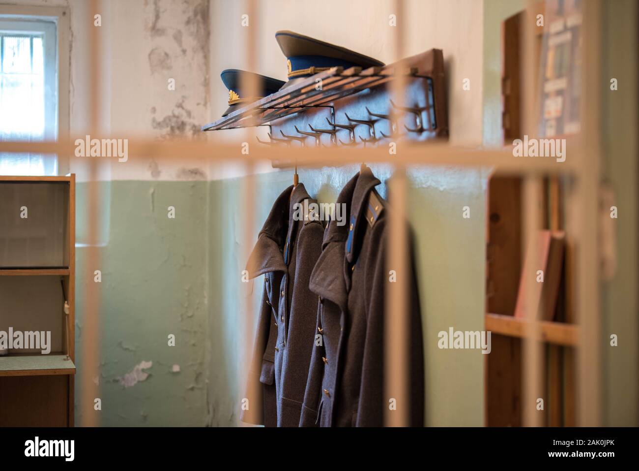 Vilnius, Lituanie : Musée des professions et de la liberté se bat (musée du KGB ou Musée des victimes du génocide), cellule de prison avec des uniformes militaires et des chapeaux Banque D'Images