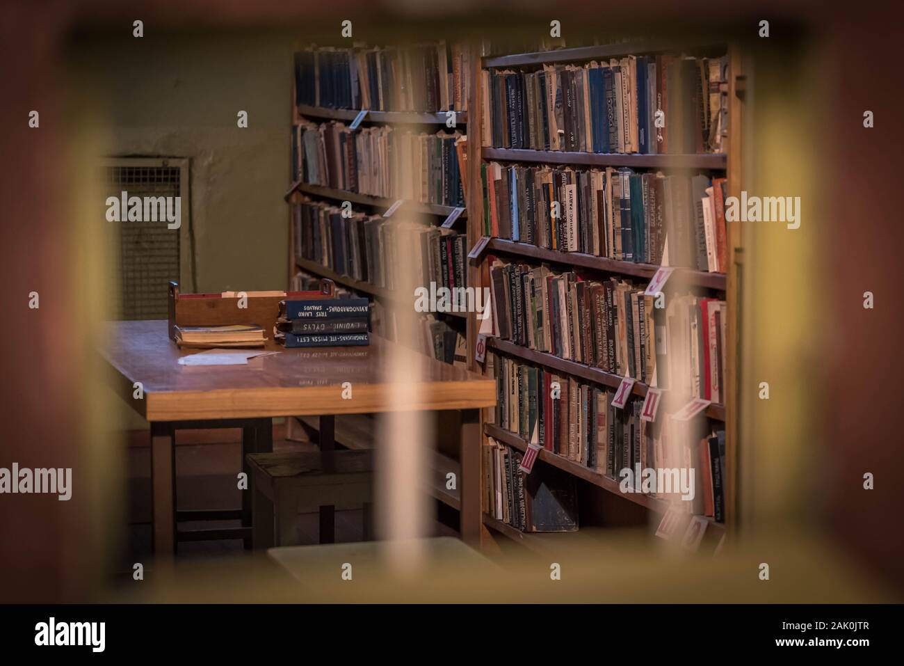 Vilnius, Lituanie : Musée des professions et de la liberté se bat (musée du KGB ou Musée des victimes du génocide), cellule de prison, des livres sur la tablette vu à travers les barreaux Banque D'Images
