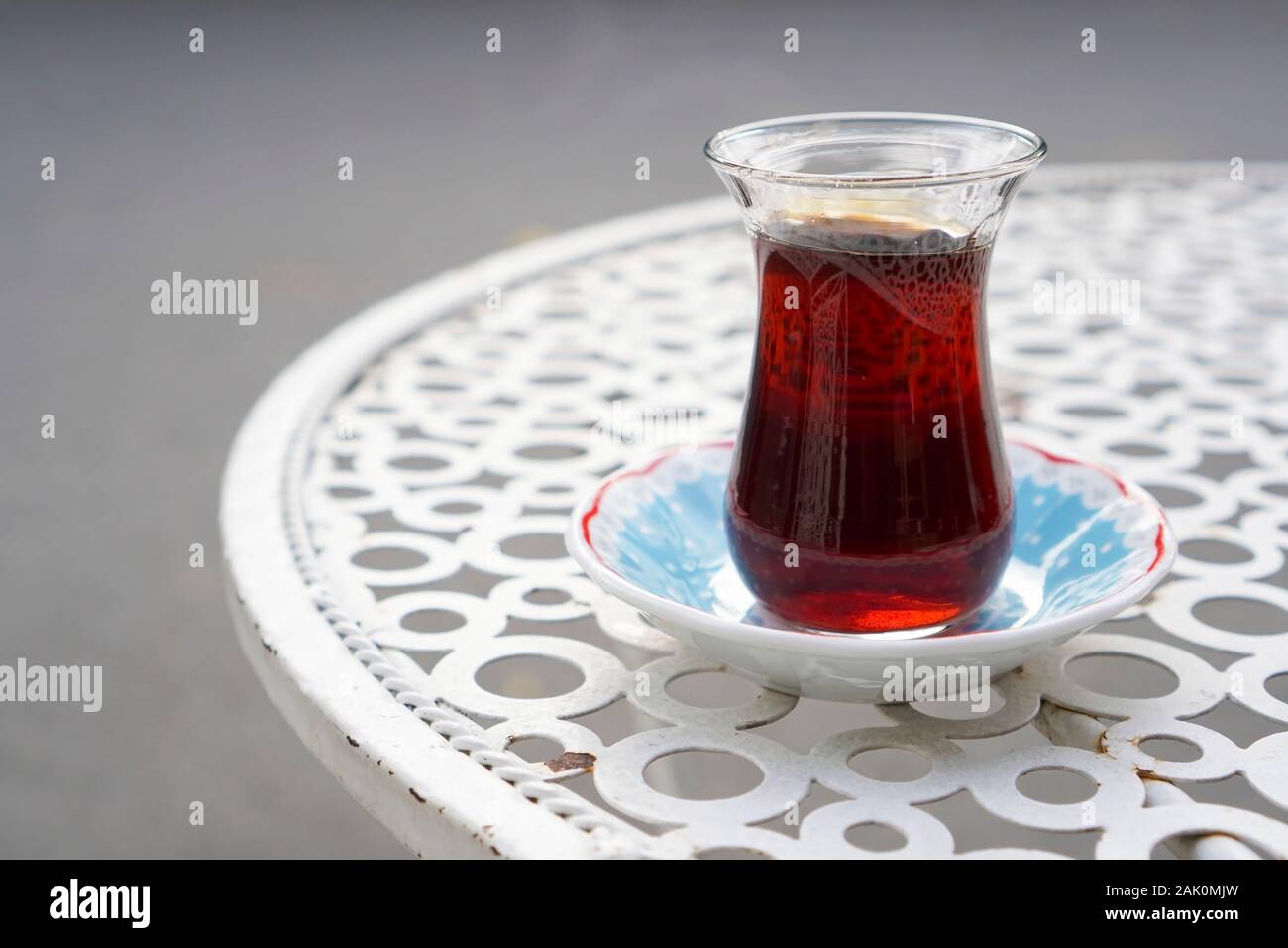 Thé servi sur un verre de thé turc sur une table à café métal street. Banque D'Images