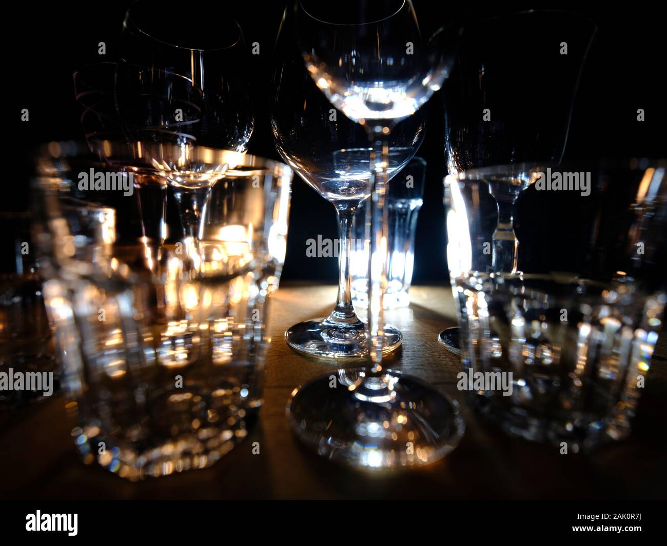 Gros plans de- vin, spiritueux et long drink--verres sur une étagère en bois dans un bar, en face d'un fond sombre, illuminé par spo colorés Banque D'Images