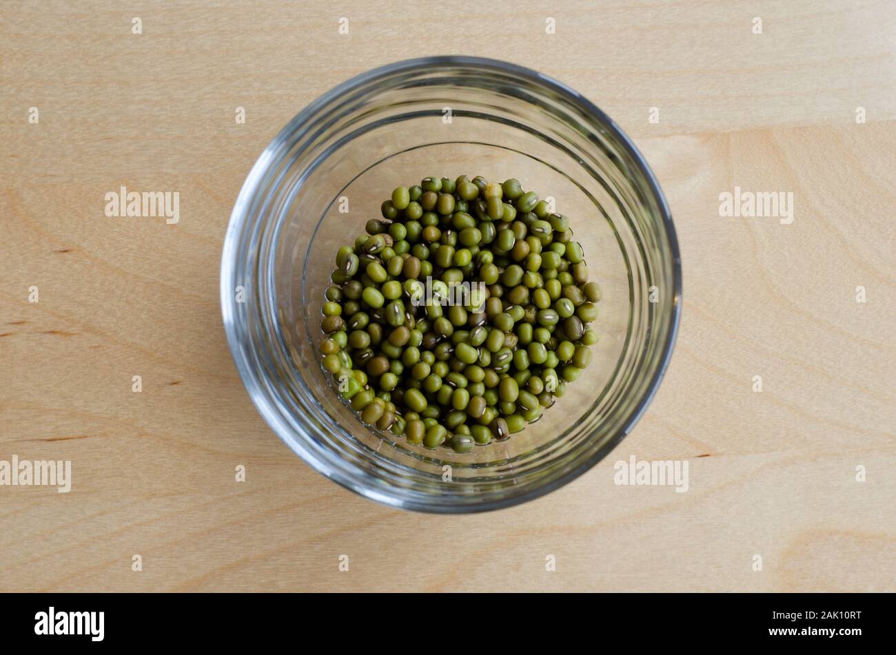 Mungbeans dans un verre sur une table en bois. Banque D'Images