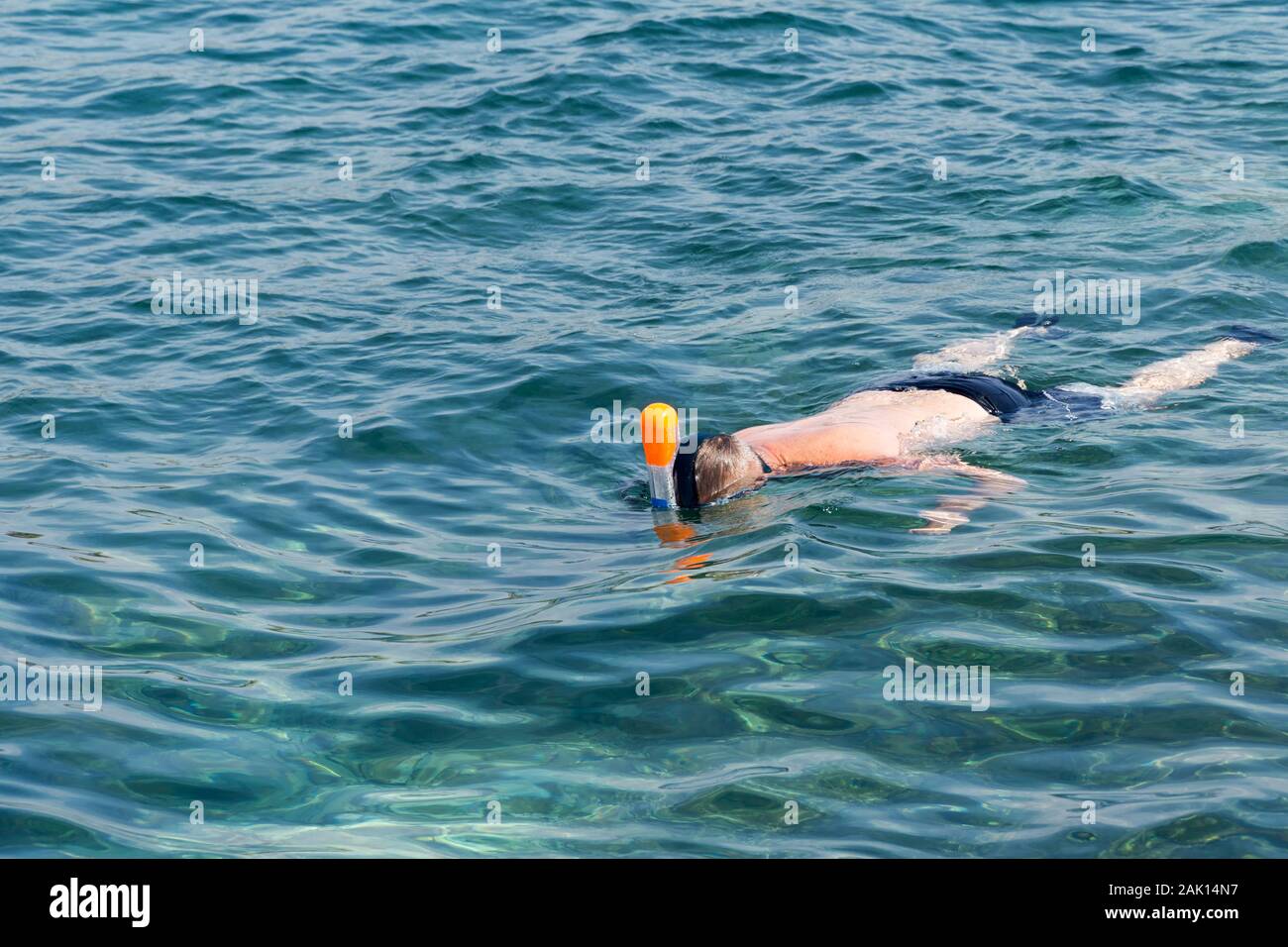 Homme natation en bleu mer peu profonde. La plongée en apnée plein-visage masque. Vacances balnéaires active. Sport d'eau en mer. Banque D'Images