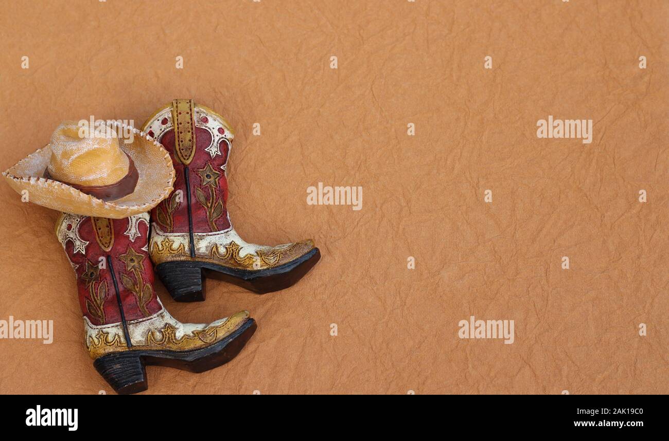 Bottes De Cow Boy Et Un Chapeau Portant Sur Un Fond Brun Texture Avec L Espace D Ecriture Photo Stock Alamy