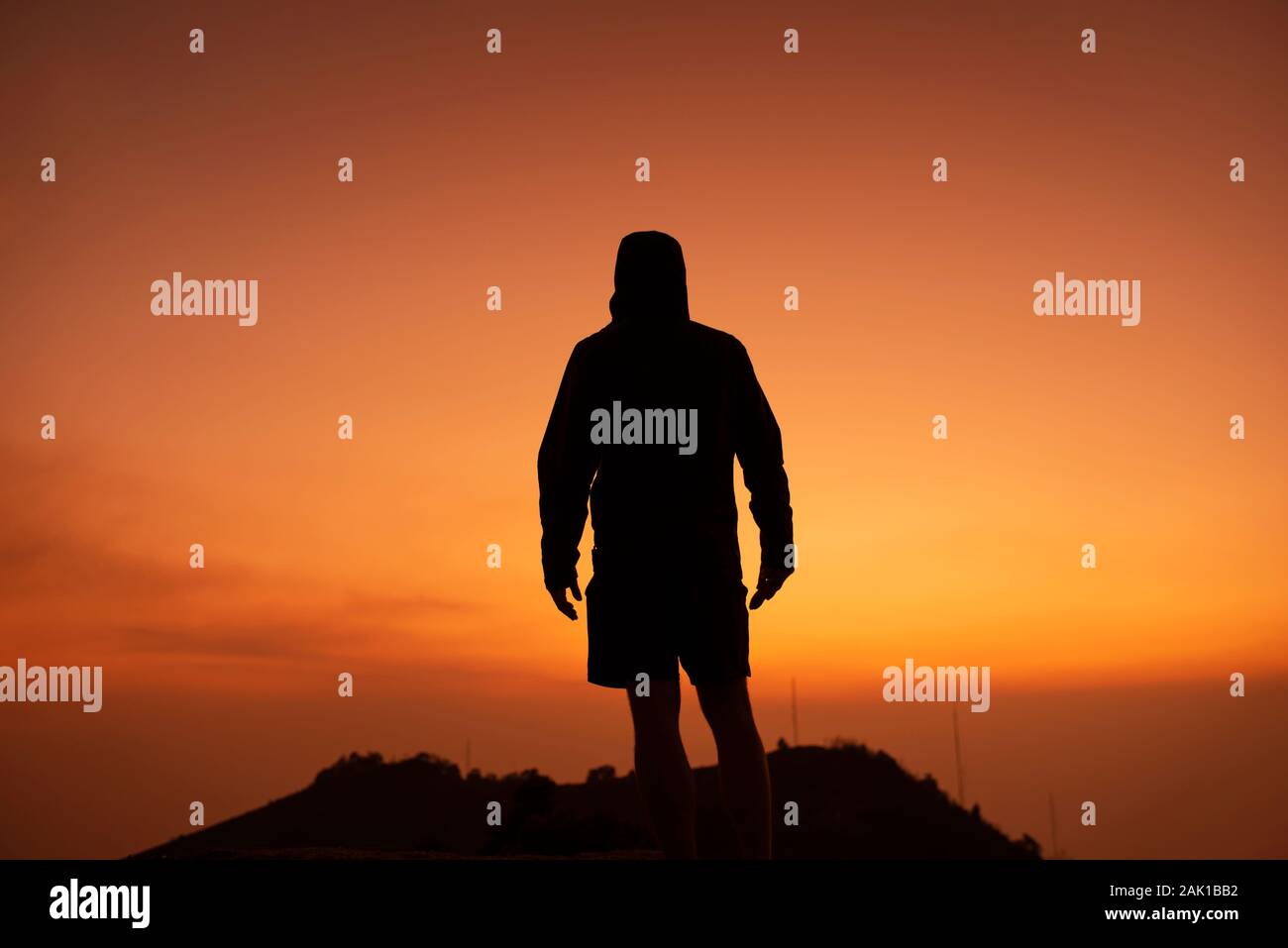 Silhouette d'un homme de dos, debout au sommet d'une colline / mountain à la recherche à un magnifique coucher de soleil. Photo de motivation conceptuelle d'inspiration RF Banque D'Images