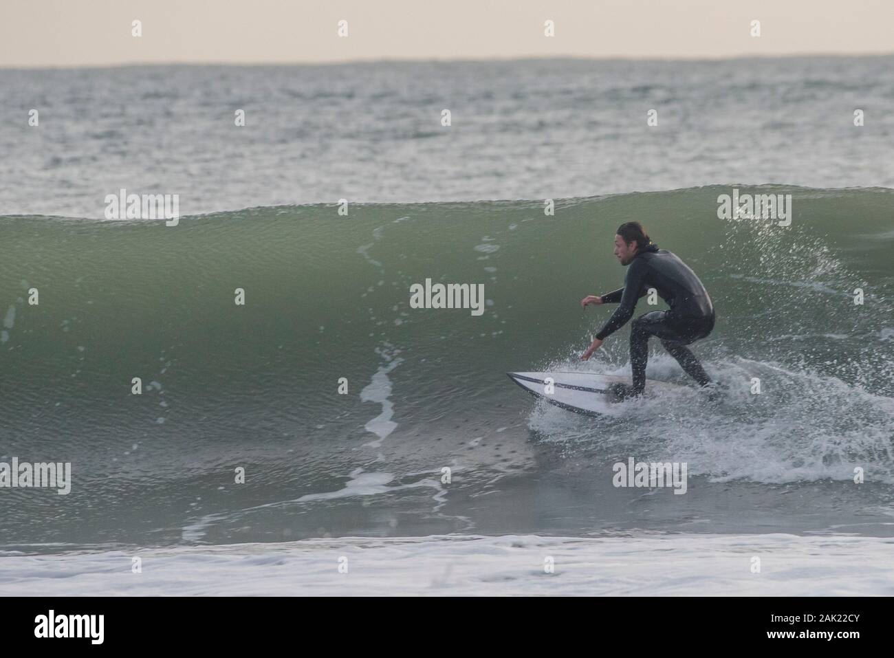 Un homme surf au large de la côte de l'Ano Nuevo State Park dans le comté de San Mateo en Californie. Banque D'Images