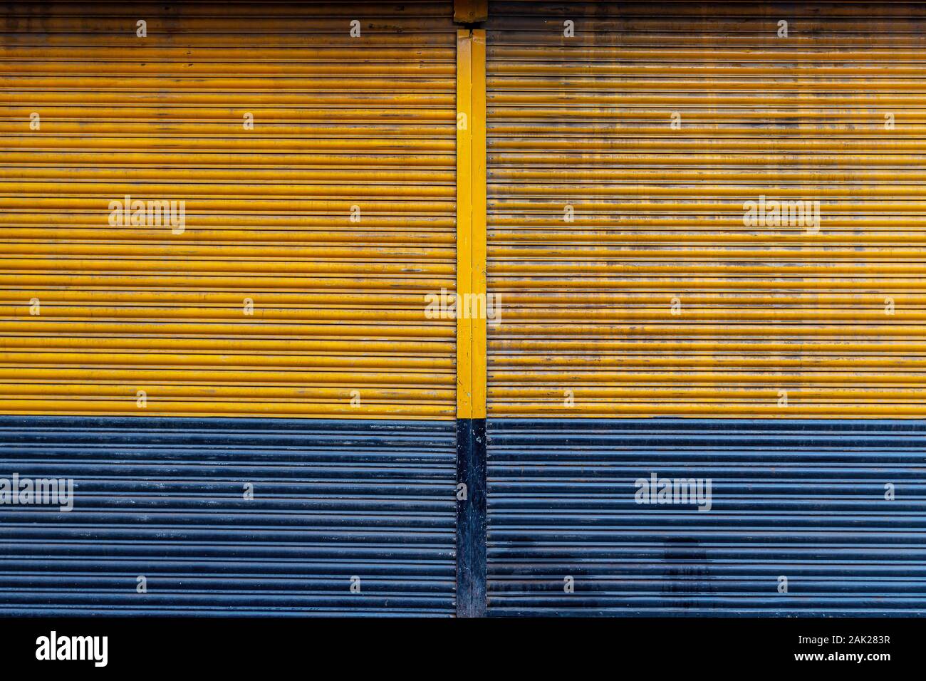 Couleur jaune et bleu rideau métallique porte arrière-plan. Banque D'Images