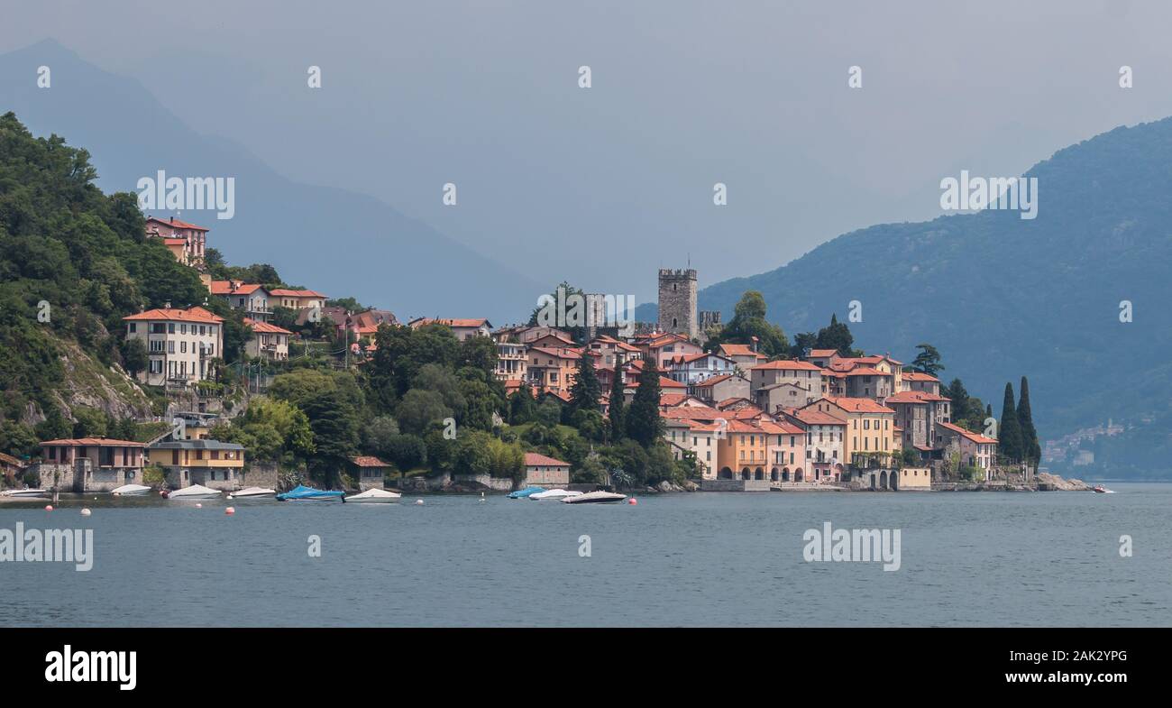 Classic Village lacustre sur le lac de Côme avec les montagnes dans la brume derrière Banque D'Images