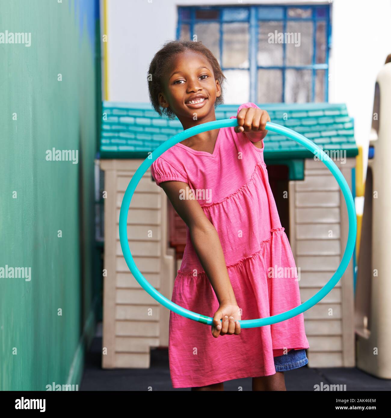 En Afrique, un enfant joue avec un pneu en maternelle Banque D'Images