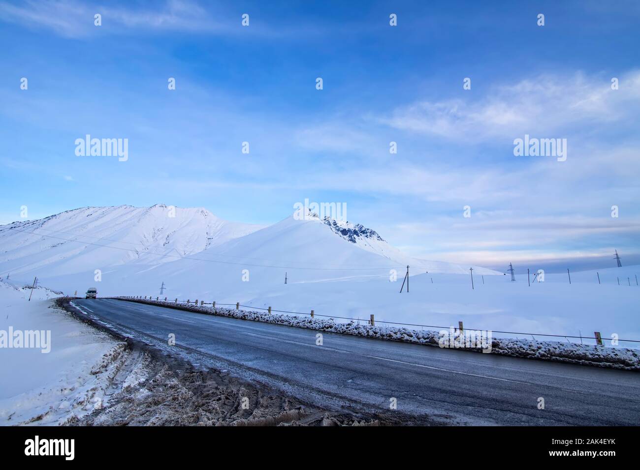 Col de la croix entre des montagnes enneigées sur la route militaire géorgienne, au coucher du soleil. La Géorgie Banque D'Images