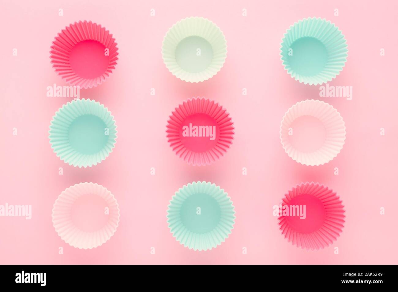 Formulaires pour la pâtisserie silikone muffins et cupcakes sur fond rose pastel Banque D'Images