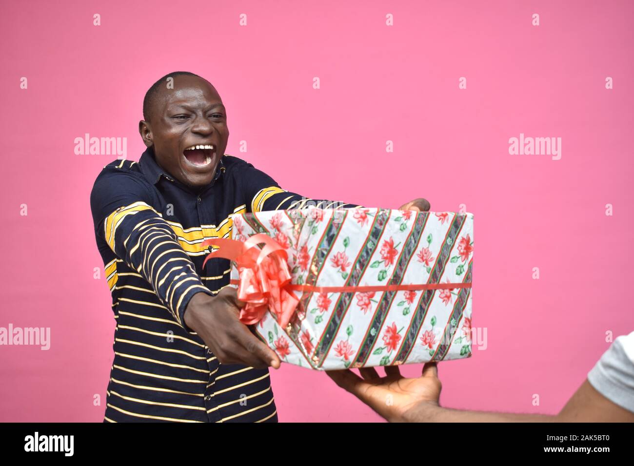 Heureux jeune homme noir sentiment super excité de recevoir un cadeau de  quelqu'un Photo Stock - Alamy