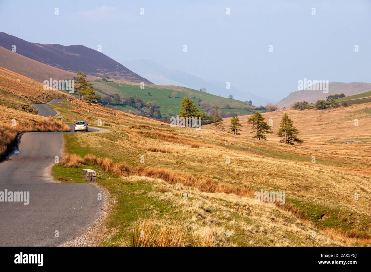 Un étroit chemin de campagne serpente à travers la lande de montagne dans la vallée de Newlands en Angleterre's Lake District National Park. Banque D'Images