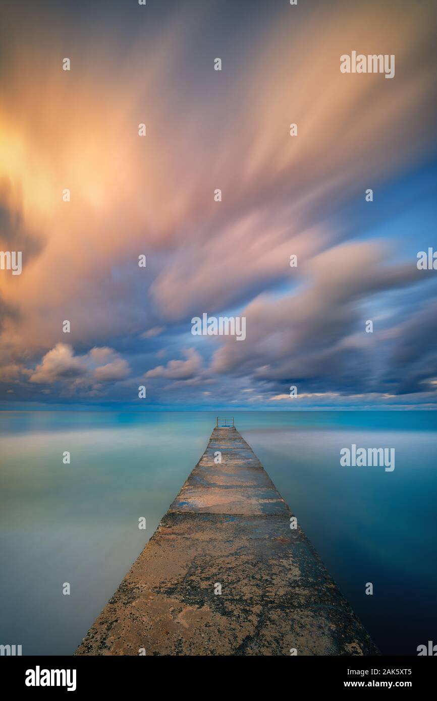 Une longue exposition seascape fine art photographie de la jetée sur un lever de soleil à Paphos, Chypre Banque D'Images