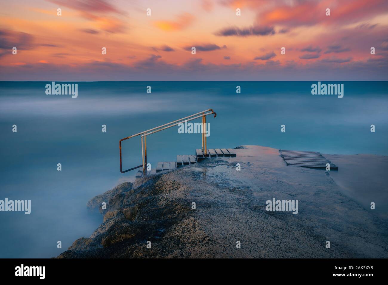 Une longue exposition seascape fine art photographie de la jetée sur un lever de soleil à Paphos, Chypre Banque D'Images