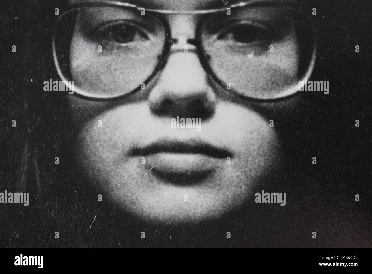 Belle photographie vintage noir et blanc des années 1970 d'une jeune femme en intention regardant l'appareil photo Banque D'Images