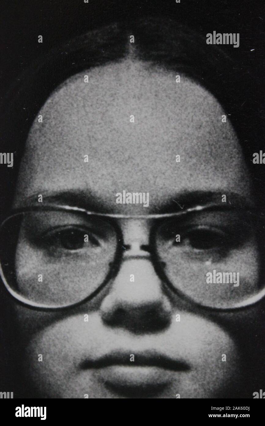 Belle photographie vintage noir et blanc des années 1970 d'une jeune femme en intention regardant l'appareil photo Banque D'Images